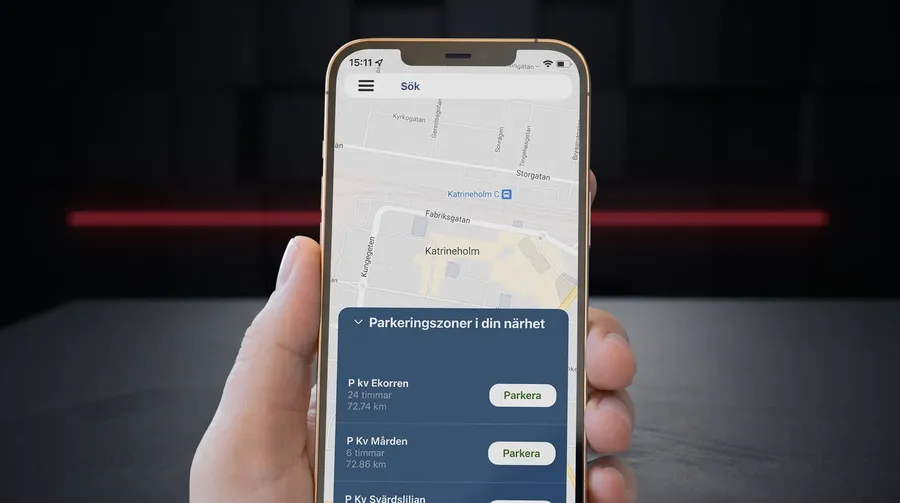 Hand som håller en mobil med Parking Times karta över parkeringszoner