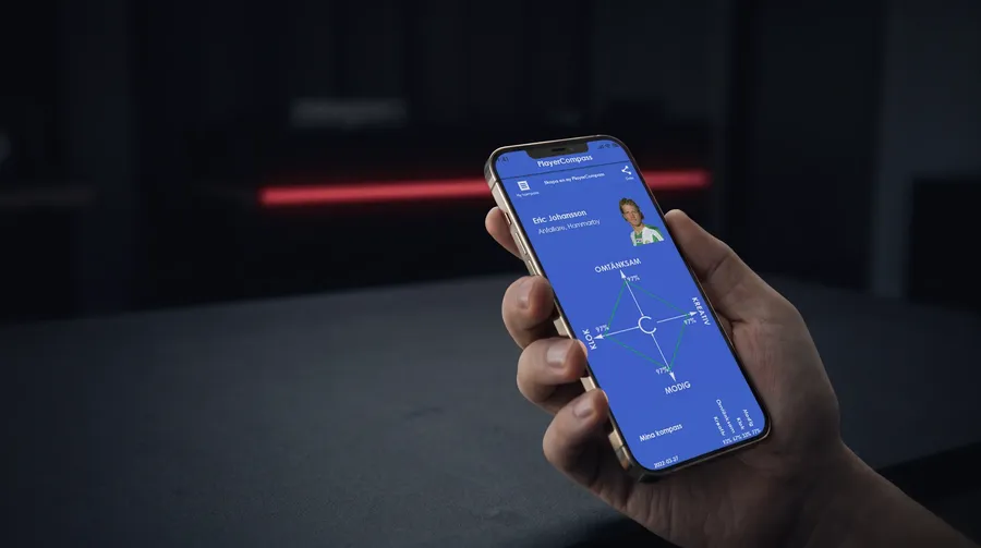 Hand som håller en mobil med spelarens kompass i Player Compass