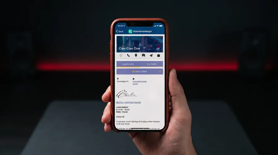Mobil med Lunch-appen som visar en restaurangs lunchmeny och en knapp för take away
