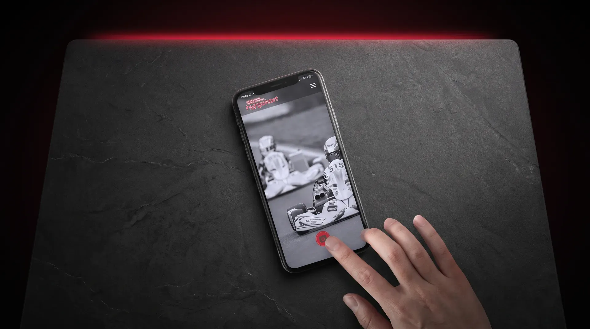Mobil med Hyrgokart-appen som visar en svartvit bild på en gokartförare
